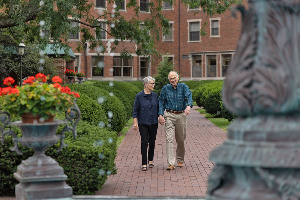 Feels-Like-Home Senior couple walking in the beautiful courtyard at Westminster Place